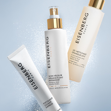 three fanned out facial lotions and cleansers against a sky-blue background