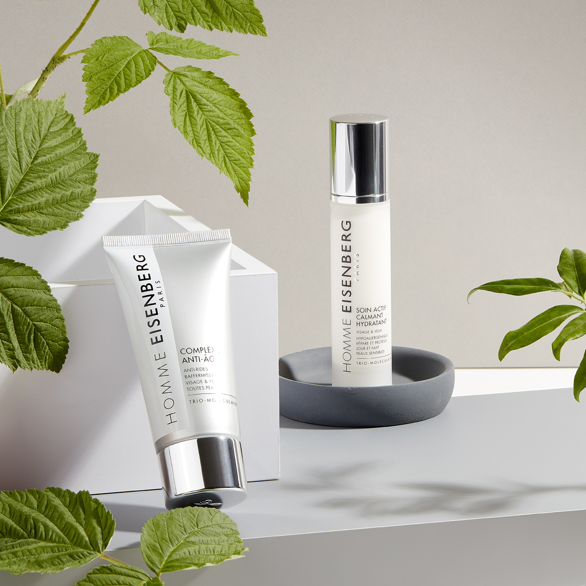 men's facial skincare with leaves on a grey and beige background