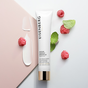 skincare for sensitive skin, its creamy texture spread next to raspeberries and leaves against a pink and grey background